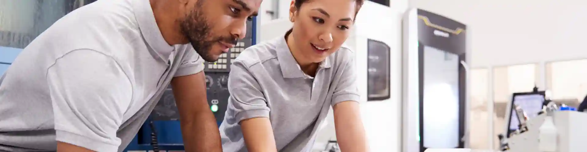 Two engineers collaborating in a manufacturing setting representing turnkey engineering services.